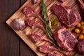 Assorted minced meat ingredients - rack of calf, ribeye, rack of lamb, with garlic, onions, red and yellow tomatoes, red pepper