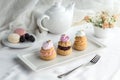 Assorted Miniature French Choux Pastry Dessert with teapot on the table
