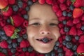 Healthy eating. Assorted mix of strawberry, blueberry, raspberry, blackberry background. Berries closeup near kids face Royalty Free Stock Photo