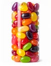 Assorted Multicolored Jelly Beans Overflowing Clear Cylinder Container on White Background Royalty Free Stock Photo