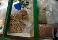 Assorted nuts in clear bags at a market stall displaying almonds and peanuts Royalty Free Stock Photo