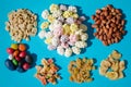 Assorted of nuts and dried fruits and dragees in sugar, on blue background, each element lies separately
