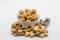 Assorted nuts in a glass bowl and isolated nutcrackers on a white background