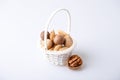 Assorted nuts in the shell on a white background: walnuts, pecans, almonds, macadamia. Nuts in a basket. Selective focus, close-up Royalty Free Stock Photo
