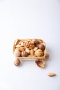 Assorted nuts in the shell on a white background: walnuts, pecans, almonds, macadamia. Nuts in a basket. Selective focus, close-up Royalty Free Stock Photo