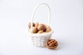 Assorted nuts in the shell on a white background: walnuts, pecans, almonds, macadamia. Nuts in a basket. Selective focus, close-up Royalty Free Stock Photo