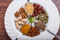 Assorted nuts in white bowl, plate on wooden surface. Top view with copy space Royalty Free Stock Photo