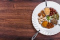 Assorted nuts in white bowl, plate on wooden surface. Top view with copy space Royalty Free Stock Photo