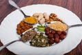 Assorted nuts in white bowl, plate on wooden surface. Top view with copy space Royalty Free Stock Photo