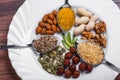 Assorted nuts in white bowl, plate on wooden surface. Top view with copy space Royalty Free Stock Photo