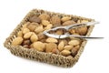 Assorted nuts in a wicker basket with a nutcracker Royalty Free Stock Photo