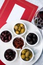 Assorted olives and sun-dried tomatoes with a glass of red wine. Place for text Royalty Free Stock Photo