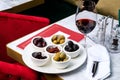 Assorted olives and sun-dried tomatoes with a glass of red wine. Place for text Royalty Free Stock Photo