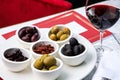 Assorted olives and sun-dried tomatoes with a glass of red wine. Place for text Royalty Free Stock Photo