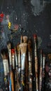 Assorted paintbrushes against a painted canvas