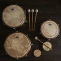 Assorted percussion instruments, including timpani and bongos, lay on a dark Royalty Free Stock Photo