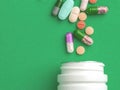 Assorted pharmaceutical medicine pills, tablets and capsules and bottle on green background. Copy space for text Royalty Free Stock Photo
