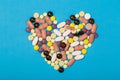 Assorted pharmaceutical medicine pills, tablets and capsules for the treatment of heart disease. Heart shape of pills Royalty Free Stock Photo