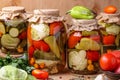 Assorted pickled vegetables in jars: cucumbers, tomatoes, cabbage, zucchini and peppers with garlic, dill and bay leaves in jars Royalty Free Stock Photo