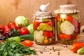 Assorted pickled vegetables in jars: cucumbers, tomatoes, cabbage, zucchini and peppers with garlic, dill and bay leaves in jars Royalty Free Stock Photo