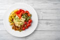 Assorted pickled vegetables with sauerkraut cabbage, peppers, cucumbers, tomatoes, mushrooms on plate on light wooden background, Royalty Free Stock Photo