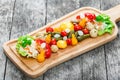 Assorted pickled vegetables - Sauerkraut cabbage, peppers, cucumbers, tomatoes, onions, mushrooms and herbs on cutting board