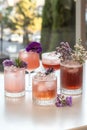 Assorted pink cocktails with floral garnishes on table Royalty Free Stock Photo
