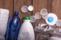 Collection of various plastic bottles and caps arranged on a wooden surface, showcasing recycling potential and environmental Royalty Free Stock Photo
