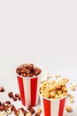 Assorted popcorn set in paper striped white red cup. Caramel and chocolate popcorn Royalty Free Stock Photo