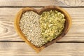 Assorted pumpkin and sunflower seeds in a heart shaped wooden plate Royalty Free Stock Photo