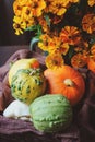 Assorted pumpkins and squash picked up in basket at country house with seasonal flowers Royalty Free Stock Photo