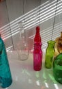 assorted rainbow colored and one clear glass bottles - various shapes Royalty Free Stock Photo