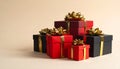 Assorted red and black gift boxes with gold ribbons and bows piled in a studio setting present Royalty Free Stock Photo