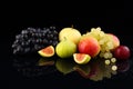 Assorted ripe fruits, grapes, apples, cherry plum and figs on black glass