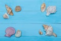 Assorted seashells on blue wooden background, flat lay, copyspace