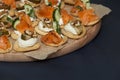 Assorted snacks and canapes with salmon, walnuts, pear and fresh cucumber on a crispy gluten-free basis. Close-up, copy space