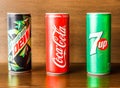 Assorted soft drink cans with coke, 7up and dew isolated on wooden background side view of indian spices and pakistani food