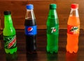 Assorted soft drink pepsi, 7 up, mirinda 245 ml and dew half litter isolated on wooden background side view cold drinks