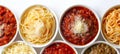 Assorted spaghetti dishes with various pastas and sauces on white background, copy space available