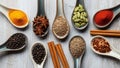 Assorted spices arranged on ceramic spoons are displayed on a wooden Royalty Free Stock Photo