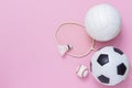 Assorted sports equipment including a basketball, soccer ball, volleyball, baseball, badminton racket on a pink background