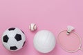 Assorted sports equipment on a pink background with copy space