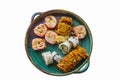 Assorted store bought sushi rolls with some ginger on a rustic platter isolated on white Royalty Free Stock Photo