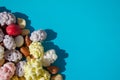 Assorted of sugared dried fruits, nuts and dragees in sugar, on blue background with copyspace