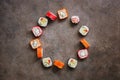 Assorted sushi roll round frame on a dark rustic background. Traditional japanese food. Top view, flat lay, copy space Royalty Free Stock Photo