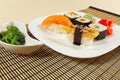 Assorted sushi and rolls and chuka salad on bamboo mat close up. Royalty Free Stock Photo