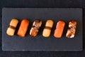 Assorted sushi with salmon, eel and escolar on black stone plate on dark background. Minimal concept