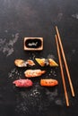 Assorted sushi set on a black stone background. Japanese food sushi, soy sauce, chopsticks. Top view, copy space Royalty Free Stock Photo