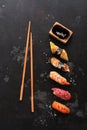 Assorted sushi set on a black stone background. Japanese food sushi, soy sauce, chopsticks. Top view, copy space Royalty Free Stock Photo