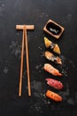 Assorted sushi set on a black stone background. Japanese food sushi, soy sauce, chopsticks. Top view, copy space Royalty Free Stock Photo